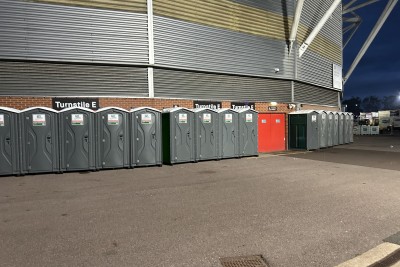 A row of loos outside of a stadium.