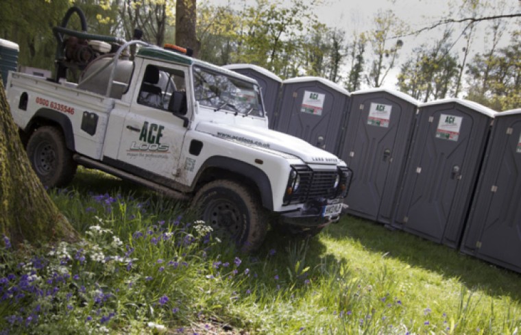 A jeep parked outside a row of loos.